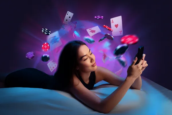 A young woman relaxing with her phone while dynamic casino elements float around her, illustrating the smooth mobile experience offered by the MOSTBED app.